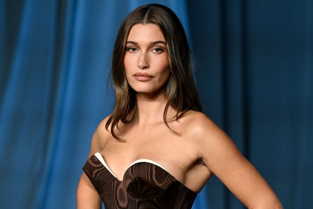 Hailey Bieber smiling at a Rhode Skin event in 2025, radiating confidence and natural beauty.